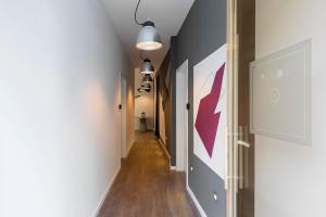 a hallway with white walls and wood floors and two lights at Ronda9 central suites in Madrid
