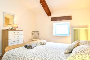a bedroom with a bed and a dresser and a window at Appartamento Sissi, romantico in centro in Levico Terme