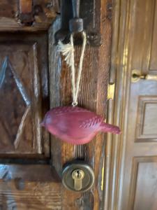 un pez rosa colgando de una puerta de madera en El Jardin de las Magnolias Hotel, en Quintana de Soba