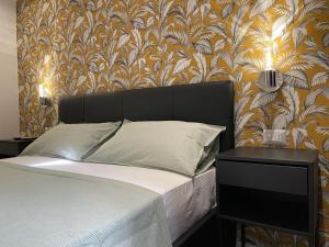 een slaapkamer met een bed en een muur met bloemenbehang bij Vatican G&G Suites in Rome