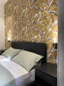 een slaapkamer met een bed met een muur met behang bij Vatican G&G Suites in Rome