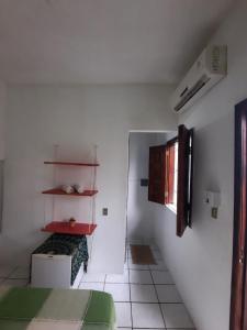 Camera bianca con letto e mensola di Ammonite Hostel - Itacaré a Itacaré