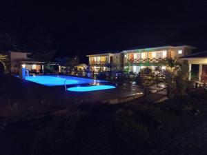 a view of a pool at night at Pousada dos Pássaros in Quartéis