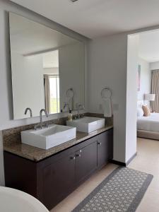 a bathroom with two sinks and a large mirror at Fabuloso departamento de lujo frente al mar in Cancún