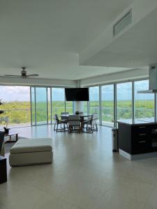 ein großes Wohnzimmer mit einem Tisch und Stühlen in der Unterkunft Fabuloso departamento de lujo frente al mar in Cancún