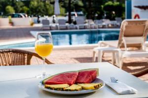 un piatto di frutta e un bicchiere di vino su un tavolo di Hostal Es Pi - Emar Hotels a Playa Migjorn