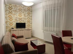 a living room with a couch and a tv at Holiday Wing Apartment 2 in Jagodina