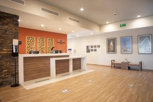 a lobby with a counter and a person in a room at Candlewood Suites - Guadalajara Galerias, an IHG Hotel in Guadalajara