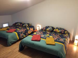a bedroom with two beds with towels on them at Entre Vignobles et Estuaire - Gîte 12 pers in Saint-Thomas-de-Cônac