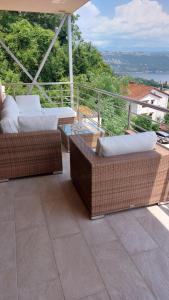 patio z wiklinowymi krzesłami i stołami na balkonie w obiekcie Apartment Leona, Opatija w mieście Opatija
