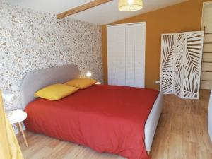 - une chambre avec un lit rouge et des oreillers jaunes dans l'établissement Maison Normande proche de la mer et des lieux touristiques, à Quettehou