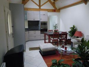 Una sala de estar con una mesa y una cocina. en Gîte Desvergnes, en Tours