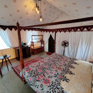 a bedroom with a canopy bed with a floral bedspread at Exotic Stay - a unique experience in Pune