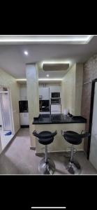 a kitchen with two bar stools in a room at Comforts apartments 1 in Fnidek