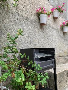 un banco negro con macetas en una pared en Vive la vida rural: Alojamiento en Les Piles. NIU RURAL, S.L., en Las Pilas