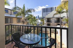 balcón con mesa, sillas y piscina en Parkview Apartments, en Brisbane