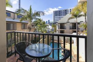 a balcony with a table and chairs and a pool at Parkview Apartments in Brisbane