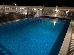 a large swimming pool with blue water at night at Ways Motel in Hampton