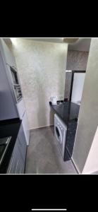 a small bathroom with a sink and a microwave at Comforts apartments 1 in Fnidek