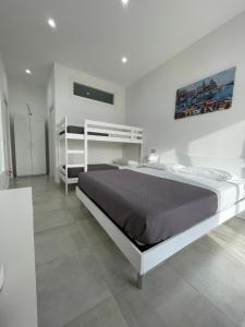 a bedroom with a large bed in a white room at Terrazza Don Mario bed&breakfast in Pozzuoli