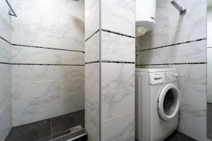 a white bathroom with a washing machine in it at Apartman Šumice in Vračar (historical)