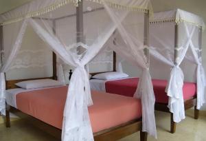 Postel nebo postele na pokoji v ubytování KARANG SARI Guesthouse & Warung