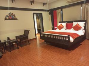 Mount Retreat Resorts - Madurai في مادوراي: غرفة نوم بسرير كبير ومخدات حمراء وبيضاء