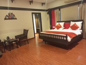 a bedroom with a large bed with red and white pillows at Mount Retreat Resorts - Madurai in Madurai