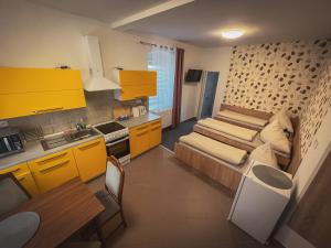 una cucina con armadi gialli e un divano in camera di Hotel Apartment Faraon a Rumburk