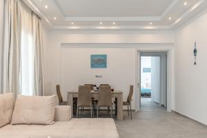 a dining room with a table and a couch at Naxos Apartment in Naxos Chora