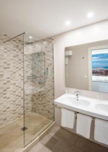 un bagno con lavandino e doccia di Hostal Es Pi - Emar Hotels a Playa Migjorn