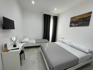 a white bedroom with a bed and a desk at Terrazza Don Mario bed&breakfast in Pozzuoli