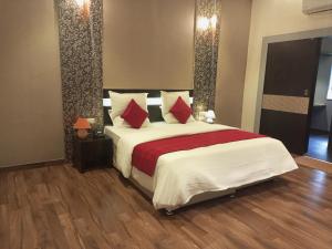 um quarto com uma cama grande e almofadas vermelhas em Mount Retreat Resorts - Madurai em Madurai