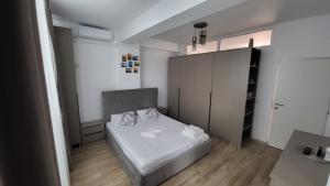 ein Schlafzimmer mit einem weißen Bett und einem Schrank in der Unterkunft Ilinca Apart- Promenada Mamaia Nord in Mamaia Nord – Năvodari