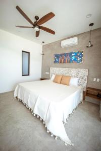 1 dormitorio con 1 cama blanca grande y ventilador de techo en Baja and Kite, en La Ventana