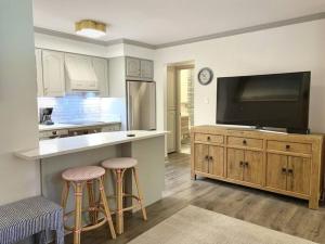 a kitchen with a television and a counter with stools at Convenience and Style, Two Q Beds in Vail