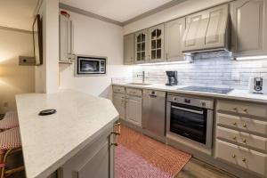 a kitchen with white cabinets and a counter top at Convenience and Style, Two Q Beds in Vail