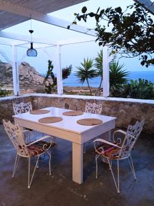 een witte tafel en twee stoelen onder een paviljoen bij Afiartis Almira Cottage in Karpathos