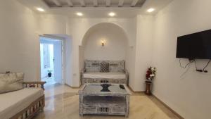 a living room with a couch and a tv at Maison Bleu in Hammamet