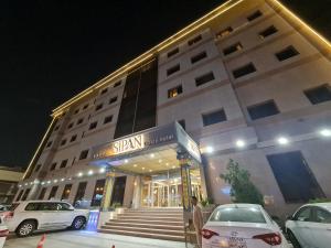 a building with cars parked in front of it at Sipan Hotel in Erbil