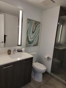 een badkamer met een toilet, een wastafel en een douche bij Lovely Condo Unit in Miami