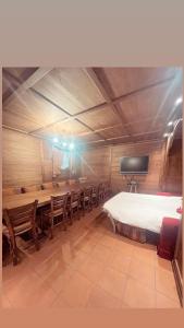 Una habitación con una cama grande y un grupo de sillas en Appartamento Paradiso Cortina, en Cortina dʼAmpezzo