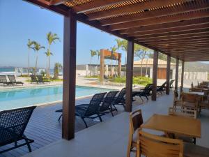 una terraza con sillas y mesas y una piscina en Deck de Búzios, en Búzios