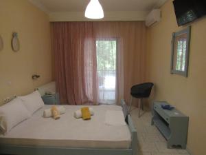 a bedroom with a bed and a desk and a window at Hotel Argilos in Asprovalta