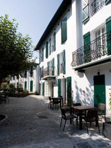 a courtyard with tables and chairs in front of a building at Hotel Residence Alaïa in Ascain