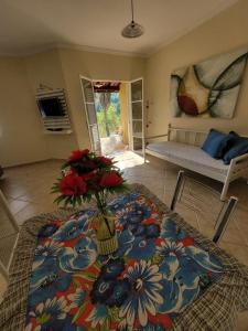 a living room with a table with flowers on it at Chalés Sitio Dois Lagos - Amparo SP in Amparo +46 photos