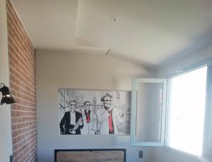 a painting of two men on a wall in a room at Grecos ART SKIATHOS in Skiathos
