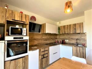 a kitchen with white appliances and wooden cabinets at Chalet rénové 7 pers avec terrasse, local ski et parking gratuit - FR-1-504-70 in Le Dévoluy +13 photos