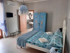 アグローポリにあるVilla Ada B&Bのベッドルーム1室(ベッド1台、青いキャビネット付)