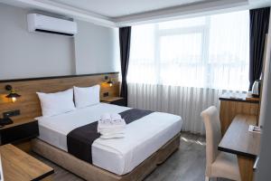 a hotel room with a bed with towels on it at Comfort Center Suit Hotel in Edirne